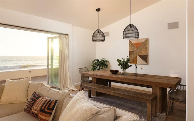 dining area featuring hardwood / wood-style floors, a water view, and lofted ceiling