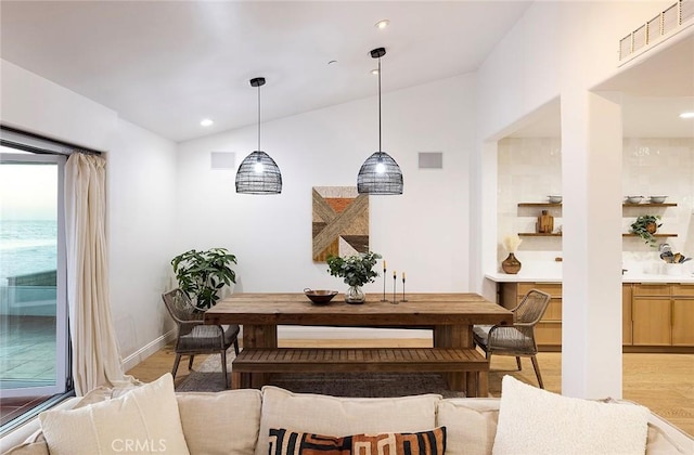 dining room with lofted ceiling and light wood-type flooring