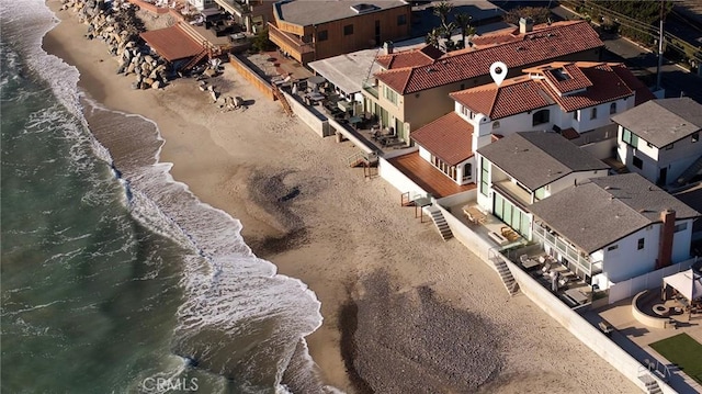 drone / aerial view featuring a water view and a view of the beach