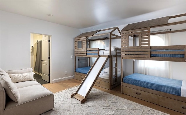 bedroom with lofted ceiling and light wood-type flooring