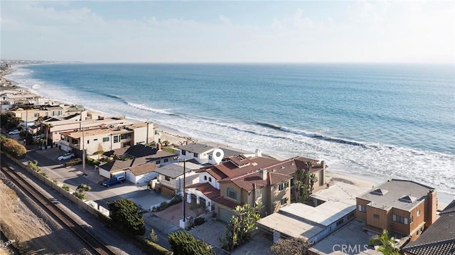 drone / aerial view featuring a water view and a beach view