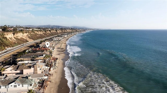 drone / aerial view with a water view and a beach view