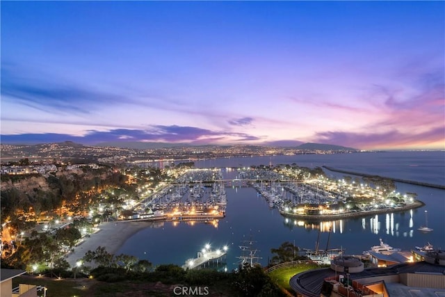 aerial view at dusk featuring a water view