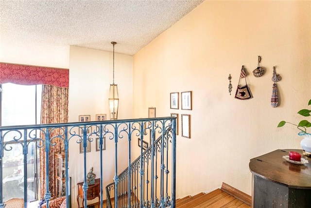 stairway featuring wood-type flooring and a textured ceiling