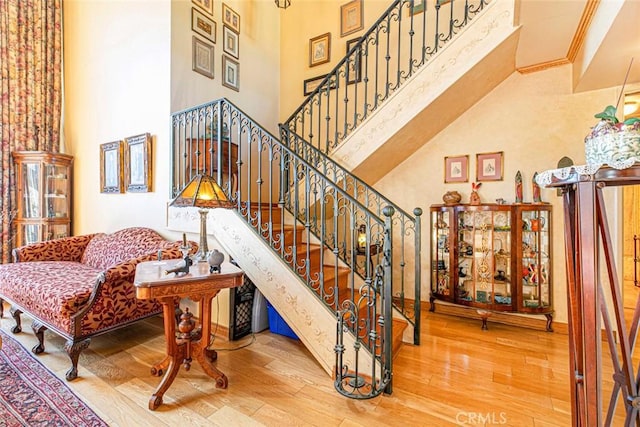 stairway featuring a towering ceiling and hardwood / wood-style flooring