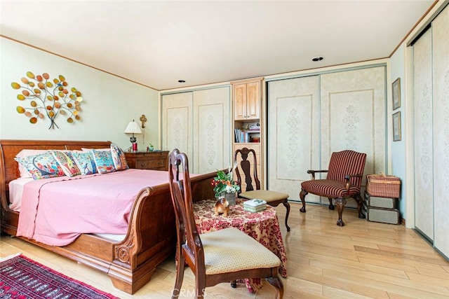 bedroom featuring multiple closets and light wood-type flooring