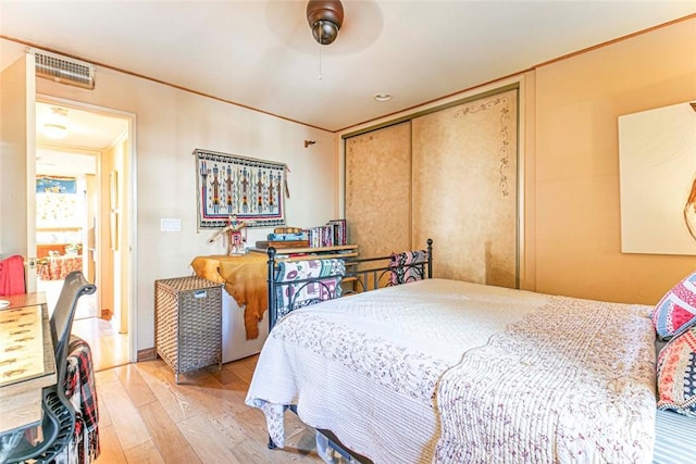 bedroom with light hardwood / wood-style flooring, a closet, and ceiling fan