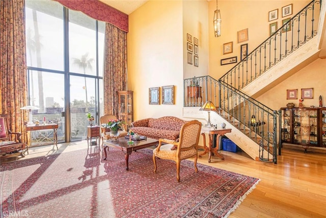 living room with hardwood / wood-style floors and a high ceiling