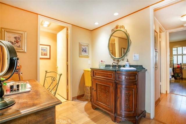 bathroom with vanity, hardwood / wood-style flooring, and ornamental molding