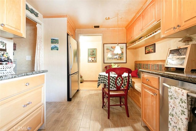 kitchen with pendant lighting, light hardwood / wood-style floors, light brown cabinets, and appliances with stainless steel finishes