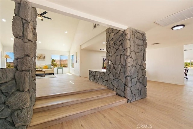 staircase with ceiling fan, hardwood / wood-style floors, high vaulted ceiling, and beam ceiling