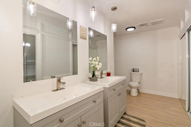 bathroom featuring toilet, hardwood / wood-style flooring, and vanity