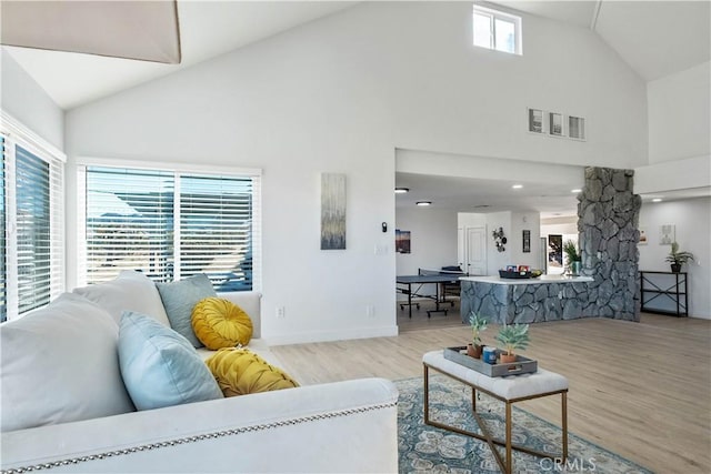 living room featuring light hardwood / wood-style flooring and high vaulted ceiling