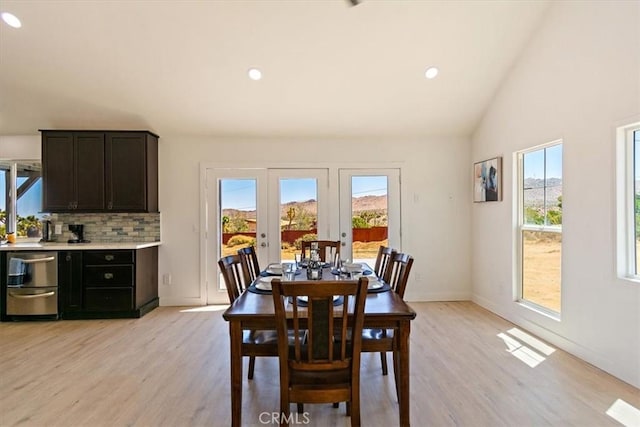 dining room with light hardwood / wood-style flooring, lofted ceiling, and french doors