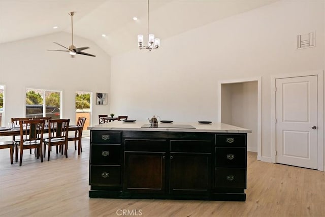 kitchen featuring a center island with sink, pendant lighting, ceiling fan with notable chandelier, light hardwood / wood-style flooring, and sink