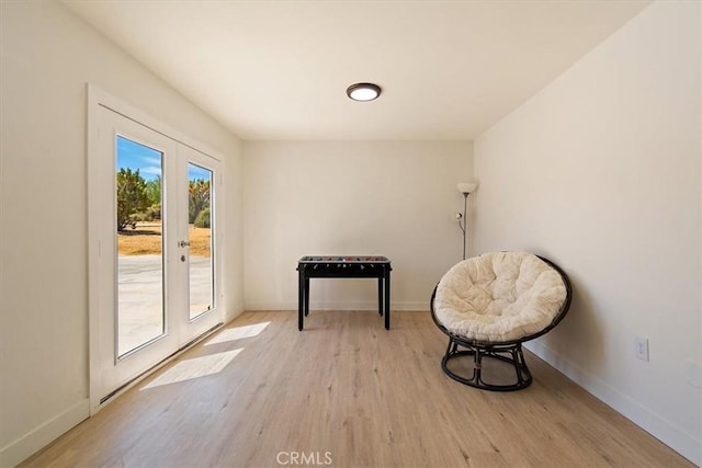 living area featuring light wood-type flooring and french doors