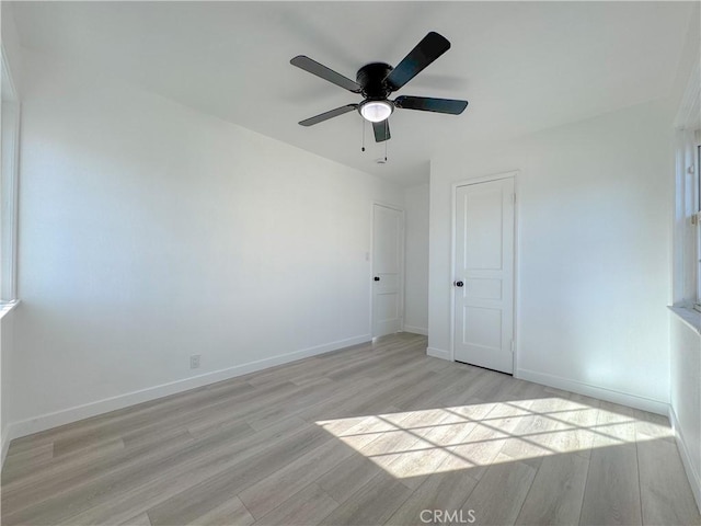 unfurnished bedroom featuring ceiling fan, light hardwood / wood-style floors, and a closet