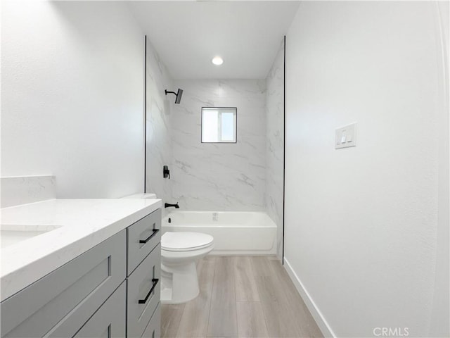 full bathroom with hardwood / wood-style floors, vanity, toilet, and tiled shower / bath combo