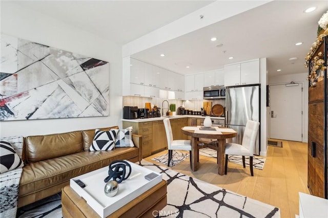 living room with light hardwood / wood-style flooring and sink