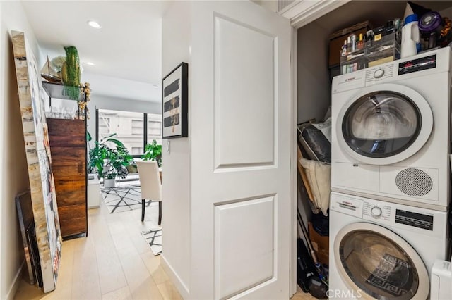 washroom featuring stacked washing maching and dryer and light hardwood / wood-style floors