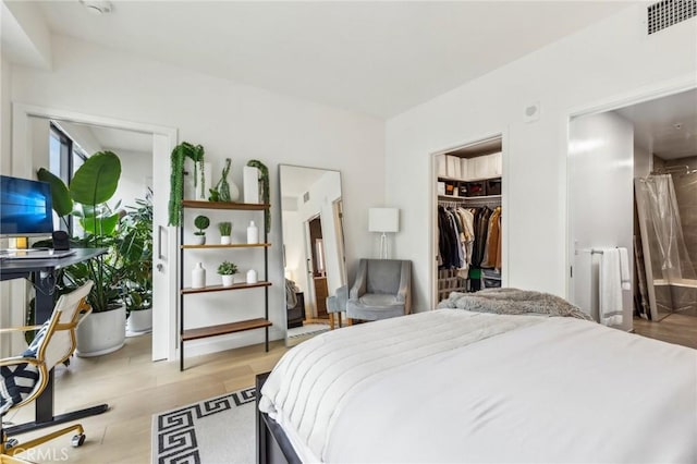 bedroom featuring light hardwood / wood-style floors, a spacious closet, and a closet