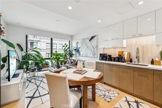 kitchen featuring light hardwood / wood-style floors, white cabinetry, and sink