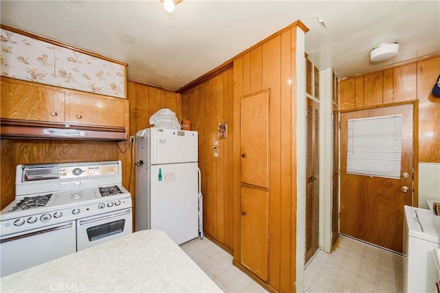 kitchen featuring wood walls and white appliances