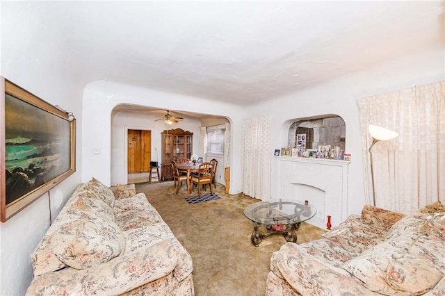 carpeted living room with ceiling fan