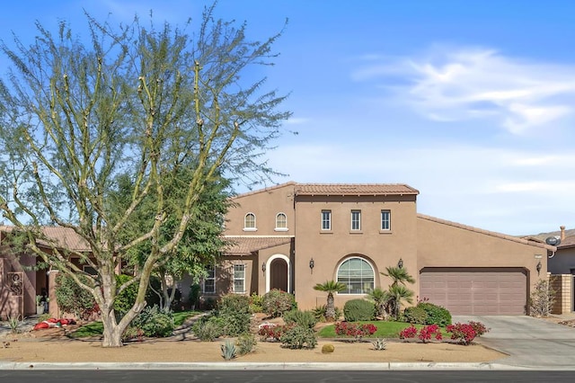 mediterranean / spanish-style home with a garage