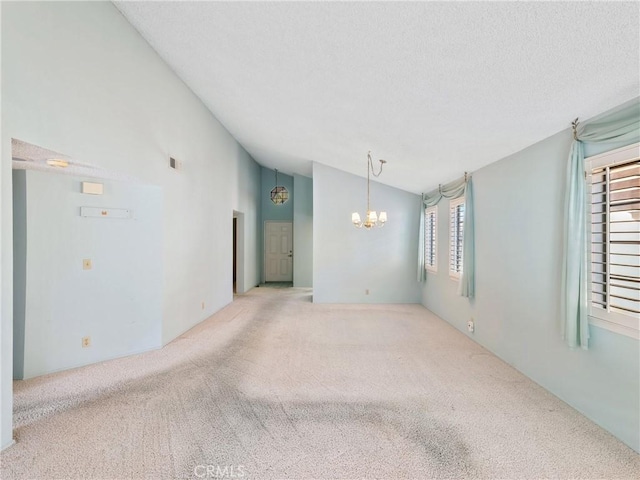 spare room with carpet floors, a healthy amount of sunlight, and vaulted ceiling