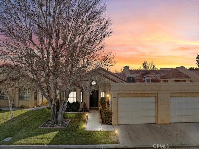 view of front of property featuring a lawn and a garage