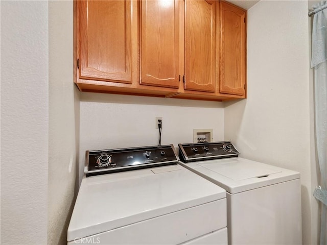 washroom featuring cabinets and washing machine and clothes dryer