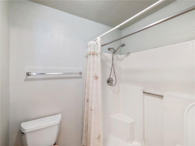 bathroom featuring a shower with curtain and toilet