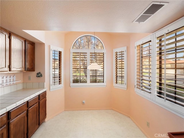 kitchen featuring tile countertops and a textured ceiling