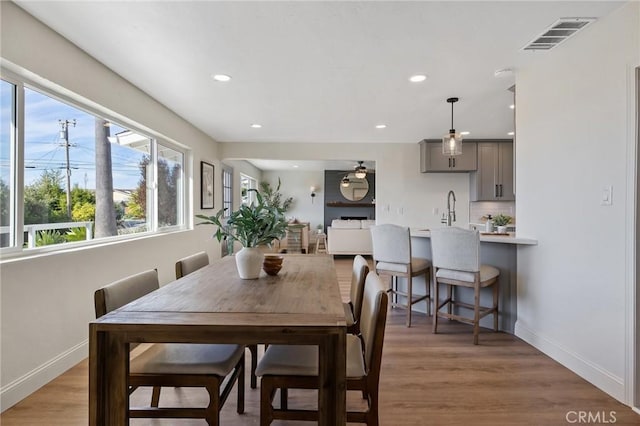 dining space with a large fireplace, dark hardwood / wood-style floors, and sink