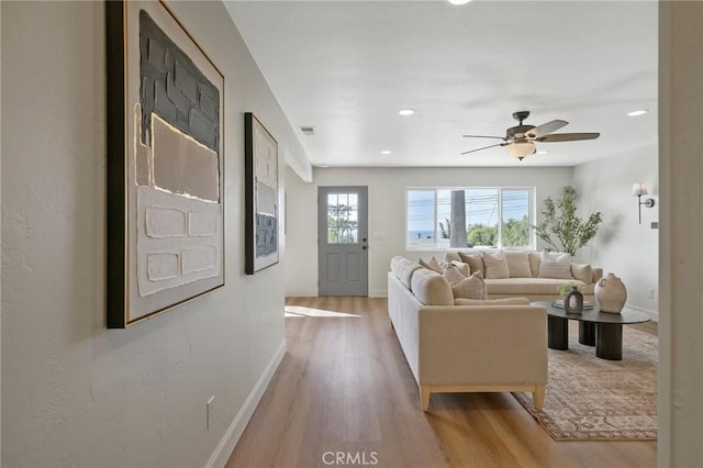 living room with ceiling fan and light wood-type flooring