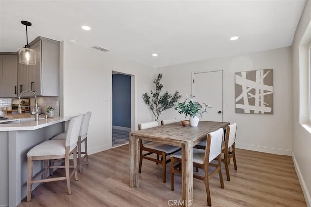 dining room with sink and light hardwood / wood-style flooring