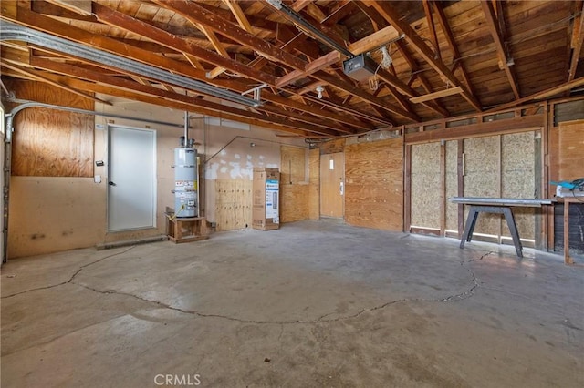 misc room with strapped water heater and concrete floors