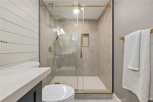 bathroom featuring toilet, an enclosed shower, and wooden walls