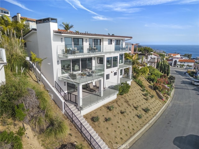 back of house featuring a water view and a balcony