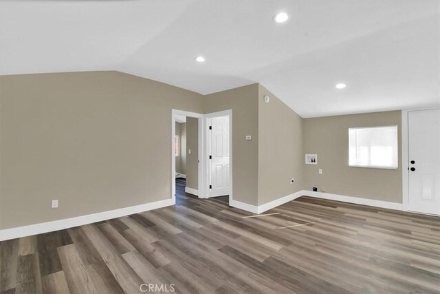 empty room featuring hardwood / wood-style flooring and vaulted ceiling