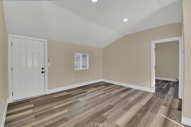 interior space with dark wood-type flooring and vaulted ceiling