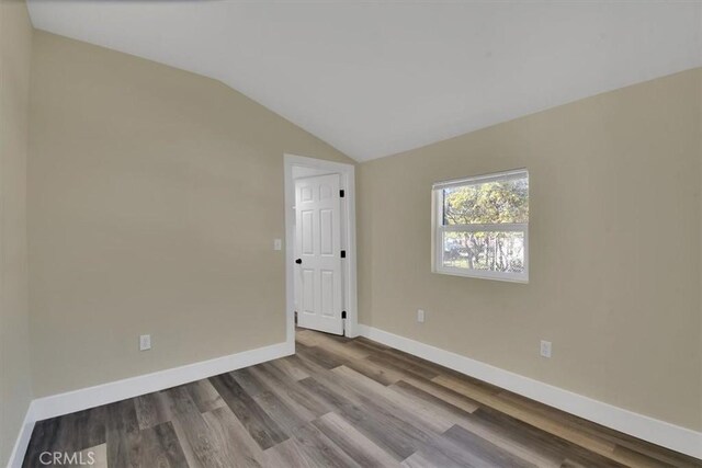 empty room featuring light hardwood / wood-style flooring and lofted ceiling