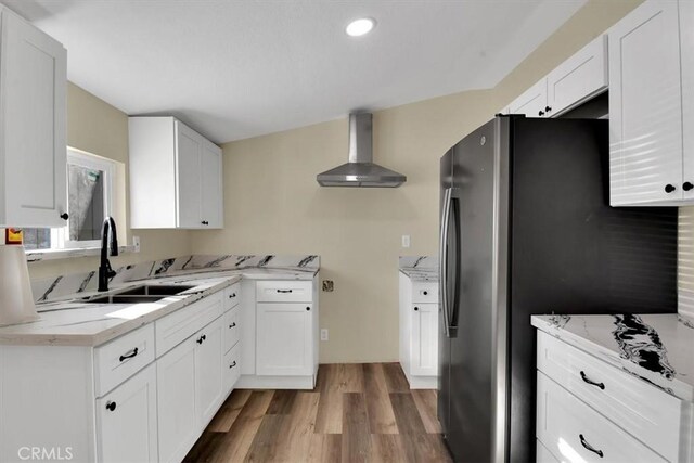 kitchen featuring dark hardwood / wood-style flooring, sink, white cabinetry, and wall chimney range hood