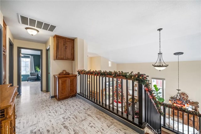 hallway with a healthy amount of sunlight and lofted ceiling