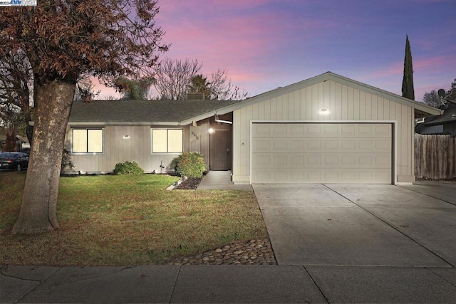 ranch-style house featuring a lawn and a garage