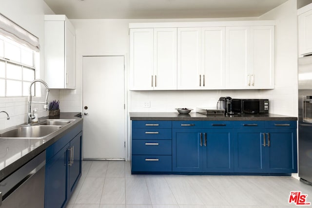 kitchen featuring decorative backsplash, appliances with stainless steel finishes, sink, blue cabinetry, and white cabinets