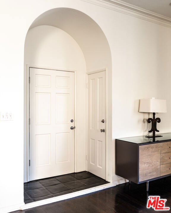 entrance foyer with dark hardwood / wood-style flooring and ornamental molding