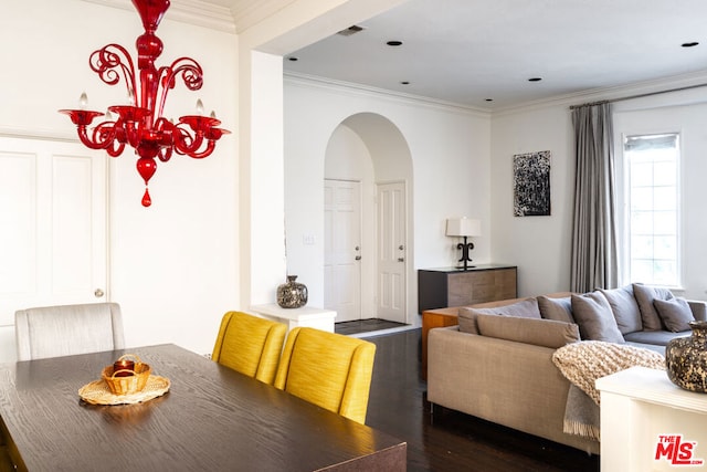 dining room featuring dark hardwood / wood-style flooring, ornamental molding, and an inviting chandelier