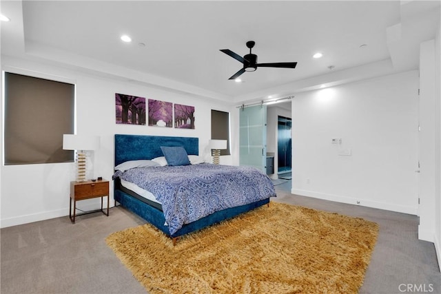 carpeted bedroom with ceiling fan and a raised ceiling